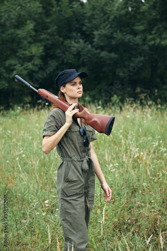 Military woman gun on shoulder hunting lifestyle green leaves