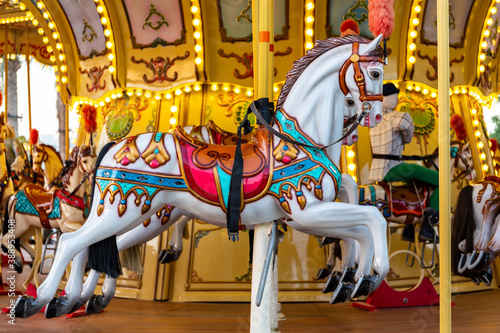 Colorful carousel horse on a vintage illuminated roundabout carousel (merry go round) in a park in Dubai, United Arab Emirates.