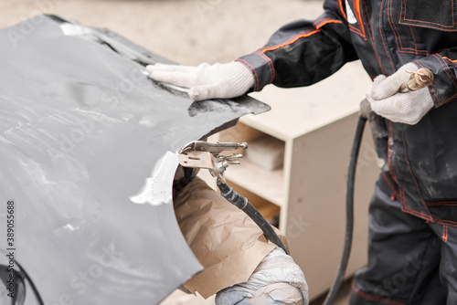 Spotter, a Welding machine for straightening dents on the car body. spot welding of metal. Repair service worker fix damaged car.