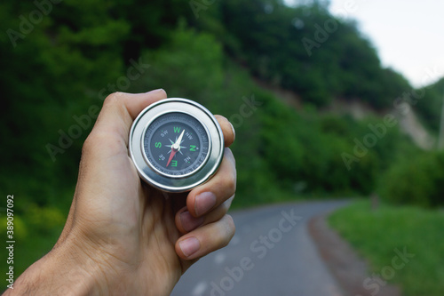 Compass in hand on a background of nature