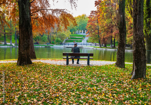 Old Gentleman with face mask sitting on park bench