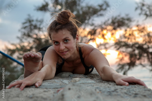 Strong and flexible woman in a Yoga pose on top of a stone wall. Shot at sunset at the old city of Jaffa.