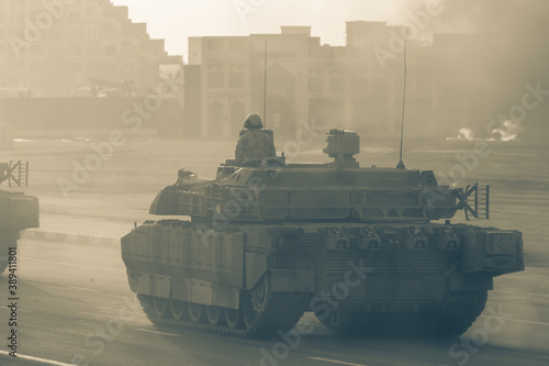 Military army tank vehicles driving down the road with guns and military personel aiming and shooting. Military and war concept of power, force, strength.