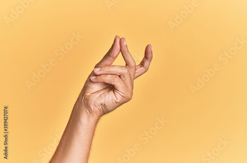 Arm and hand of caucasian man over yellow isolated background snapping fingers for success, easy and click symbol gesture with hand