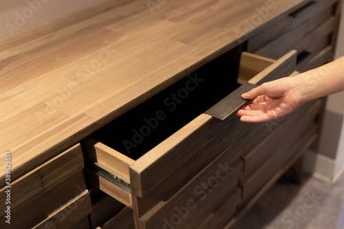 Woman open shelf, pull open drawer wooden in cabinet.