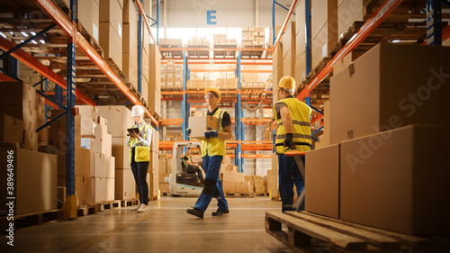 Retail Warehouse full of Shelves with Goods in Cardboard Boxes, Workers Scan and Sort Packages, Move Inventory with Pallet Trucks and Forklifts. Product Distribution Logistics Center.