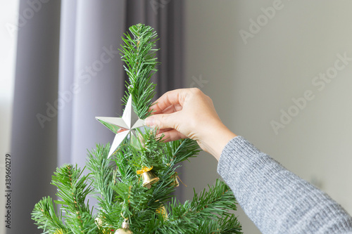 Closeup of woman hand decorate the Christmas tree for Christmas pary