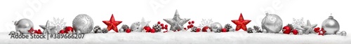 Christmas border or banner with stars and baubles arranged in a row on snow, extra wide and isolated on white background 