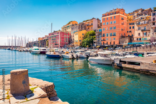 Colorful houses on the shore of Bastia port. Bright morning view of Corsica island, France, Europe. Magnificent Mediterranean seascape with yacht. Traveling concept background.