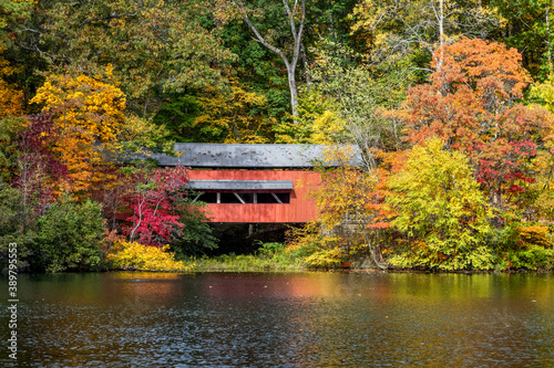 With beautiful reflections on Lake Loretta in Alley Park, Lancaster, Ohio, the red George Hutchins Covered Bridge, surrounded by colorful autumn leaves, was constructed in 1865 at another location.