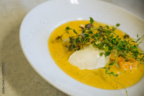 Yellow saffron soup with creme fraiche and fresh thyme on top