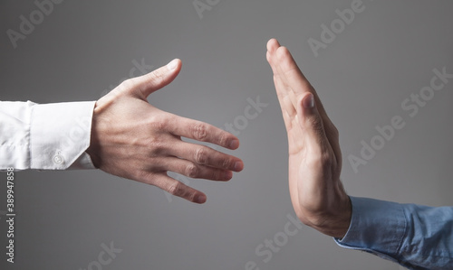 Man is refusing shake hand with businessman.