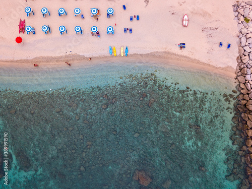 Aerial view of a beach and umbrellas. Tropea, Calabria, Italy. Parghelia. Overview of seabed seen from above, transparent water. Swimmers, bathers floating on the water. Lido La Grazia 