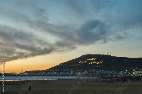 Evening beach in Agadir, Morocco. The text on the hill "The God. The country. The king."
