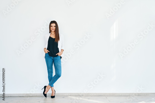 Full length portrait of smiling stylish woman posing on white background