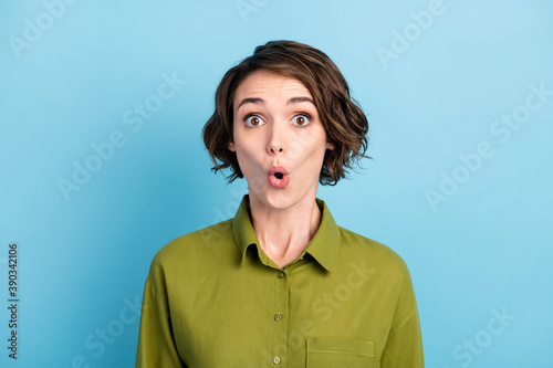 Portrait photo of shocked surprised female student wearing short wavy hairdo starring with opened mouth isolated on blue color background