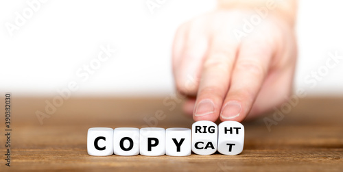 Hand turns dice and changes the word "copy cat" to "copyright".