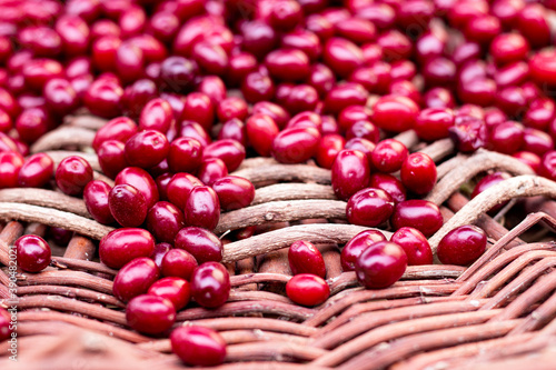 Fresh dogwood red berries on wooden basket. Fresh cornel berries. Selective focus.