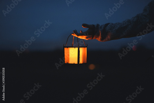 Hand holding a lantern in the dark