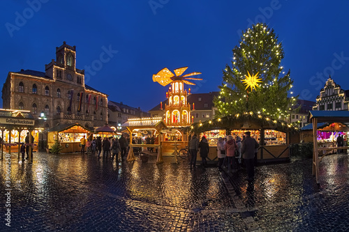 Weimar, Germany. Panoramic view of Christmas market at Market Square in dusk. The neo-Gothic Town Hall is located at the left part of image. The Renaissance Stadthaus building is visible on the right.