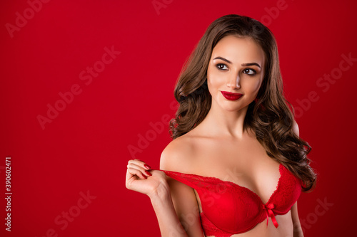 Photo portrait of dreamy girl taking off brassiere isolated on vivid red colored background with blank space