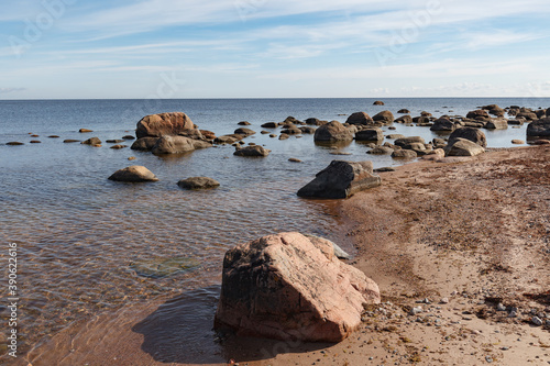 Granite stones on the beach of the Gulf of Finland in bright summer day
