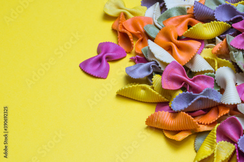 Rainbow color pasta isolated on yellow bristol paper background with copy space 