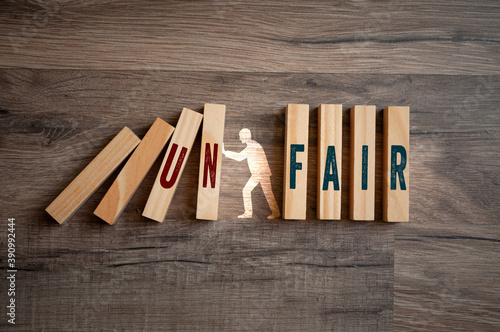 Pieces of wood with message fair and unfair on wooden background