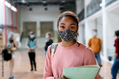 African-american student with face mask back at college or university, coronavirus concept.