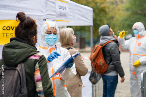 People waiting in covid-19 testing center outdoors on street, coronavirus concept.