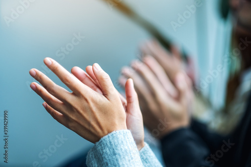 Closeup image of people clapping hands together