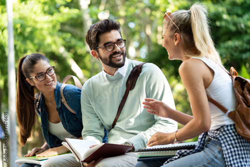 Happy group of friends studying and talking together at university