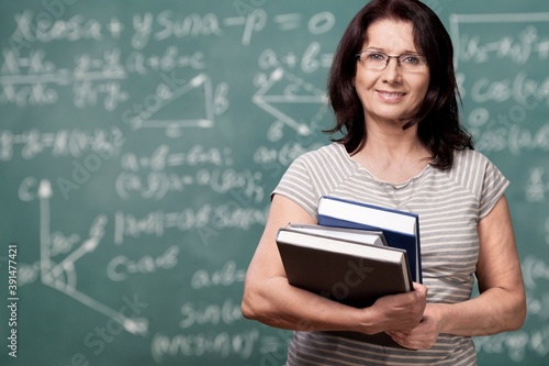 Smile woman teacher with books on background