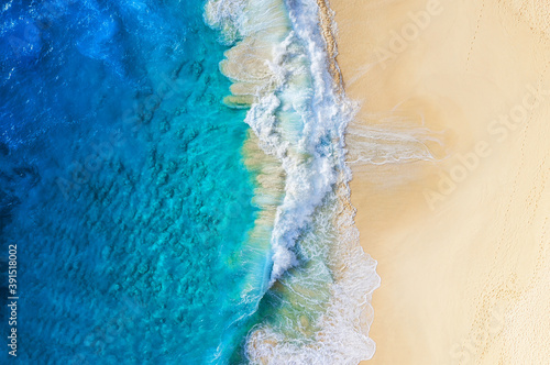 Beach and large ocean waves. Coast as a background from top view. Blue water background from drone. Summer seascape from air. Travel image