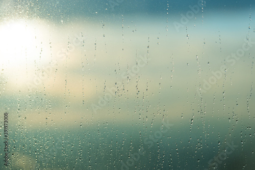 Rain water drops pattern on blue window glass surface