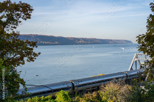 Amtrak train going along Hudson river with a few boats on the water