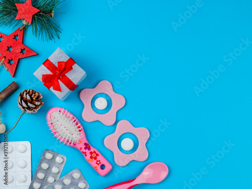 tablets and baby supplies. tablets, baby supplies, gift and christmas decor on the left on blue background with place for text on the right, top view close-up
