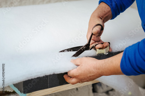 Furniture maker cutting a sofa padding
