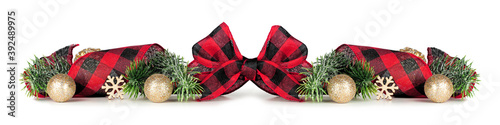 Christmas border of gold ornaments, branches and red and white checked buffalo plaid ribbon isolated on a white background