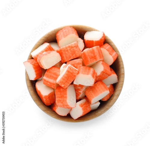 Cut crab sticks in bowl on white background, top view