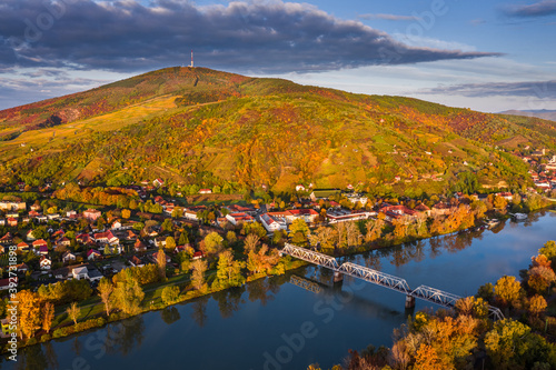 Tokaj, Hungary - Aerial panoramic view of the small town of Tokaj with golden vineyards on the hills of wine region on a warm sunny autumn morning. River Tisza and blue sky and clouds
