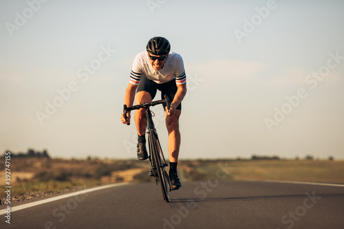 Happy road cyclist in protective helmet training outdoors