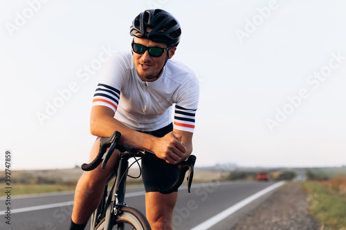 Smiling cyclist sitting on bike outdoors