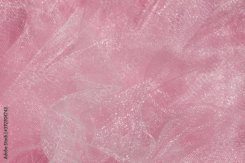 Pink tulle fabric texture top view. Coral background. Fashion color trends feminine tutu skirt flat lay, female blog backdrop for text signs desidgn. Girly abstract wallpaper, textile surface.