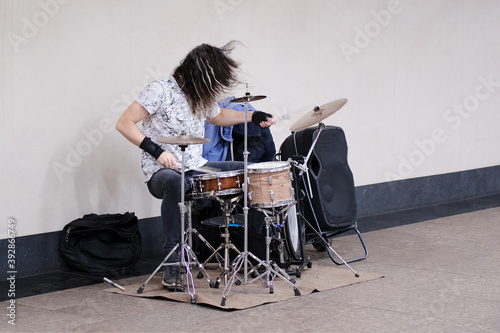 Male musician drummer playing a musical instrument at a public transport station