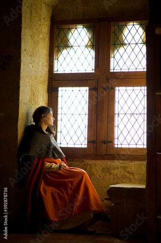 Jeune femme château médiéval attend à la fenêtre - princesse
