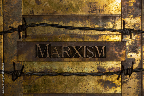 Marxism text on vintage textured grunge copper and gold background lined with barbed wire