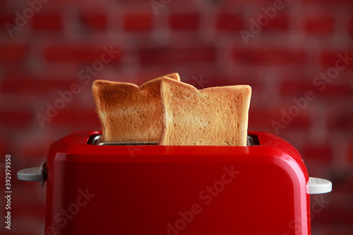 toaster with toasted sliced bread on wooden background. Kitchen equipment