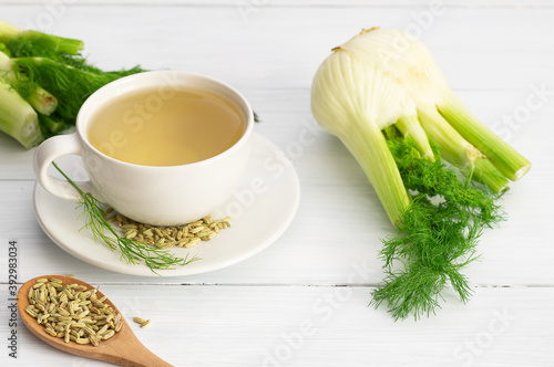 Herbal infusion fennel tea in glass cup or mug with dried fennel seeds and fennel bulbs. Alternative medicine background concept (Foeniculum vulgare)