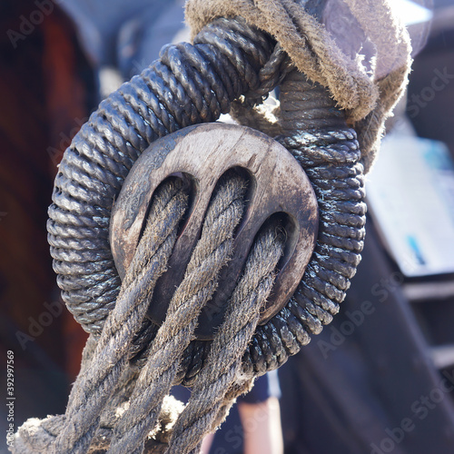 Old fashioned wooden dead eye rigging block on a sailing ship.